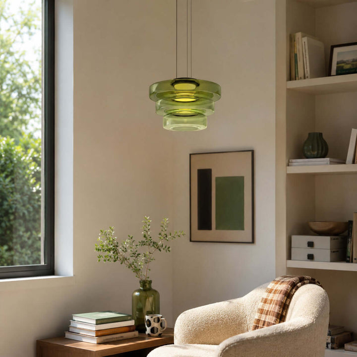 Green three-layer glass pendant light in a bright living room reading area with built-in shelves