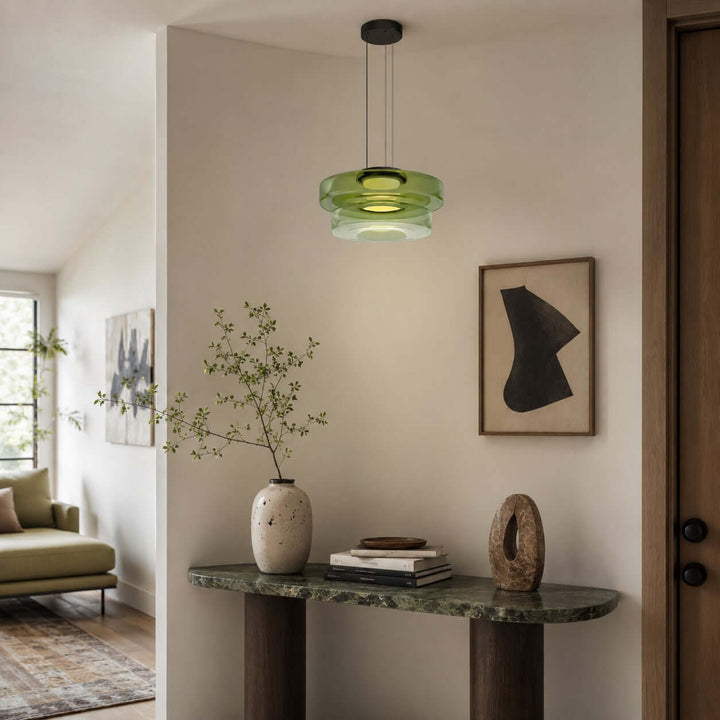 Green two-layer glass pendant light above a marble console in a modern entryway