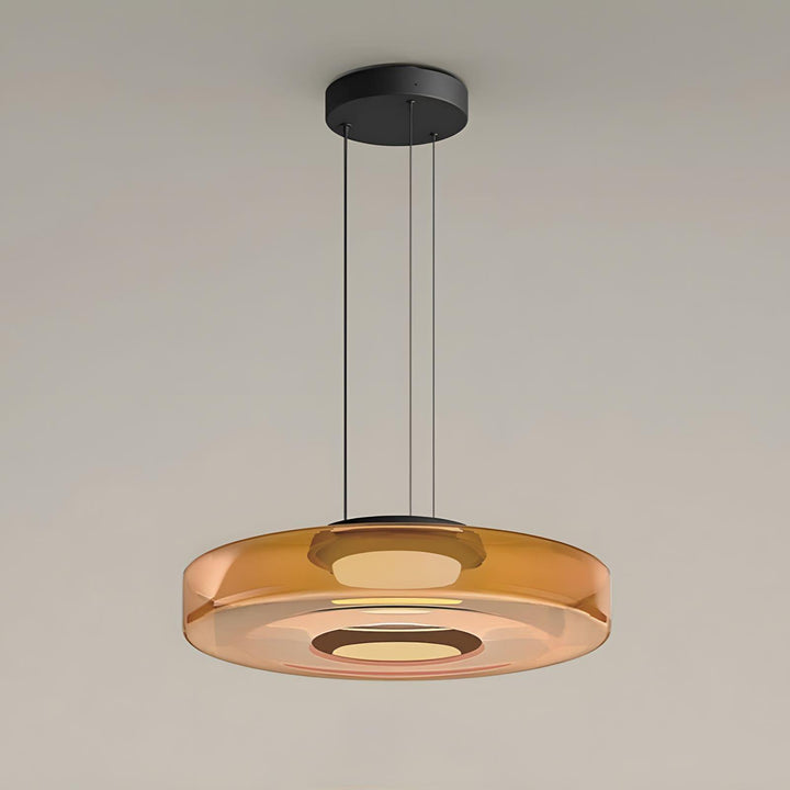 Orange one-layer glass pendant light with translucent disc shade and black ceiling mount