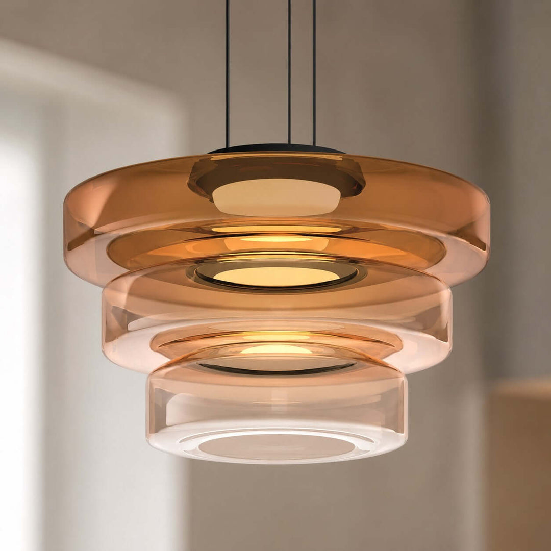 Close-up of an orange three-layer glass pendant light with graduated sculptural shades