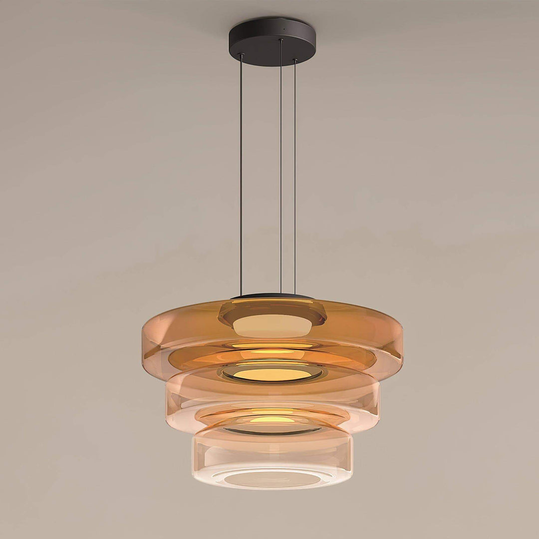 Full view of an orange three-layer glass pendant light with black canopy and adjustable suspension
