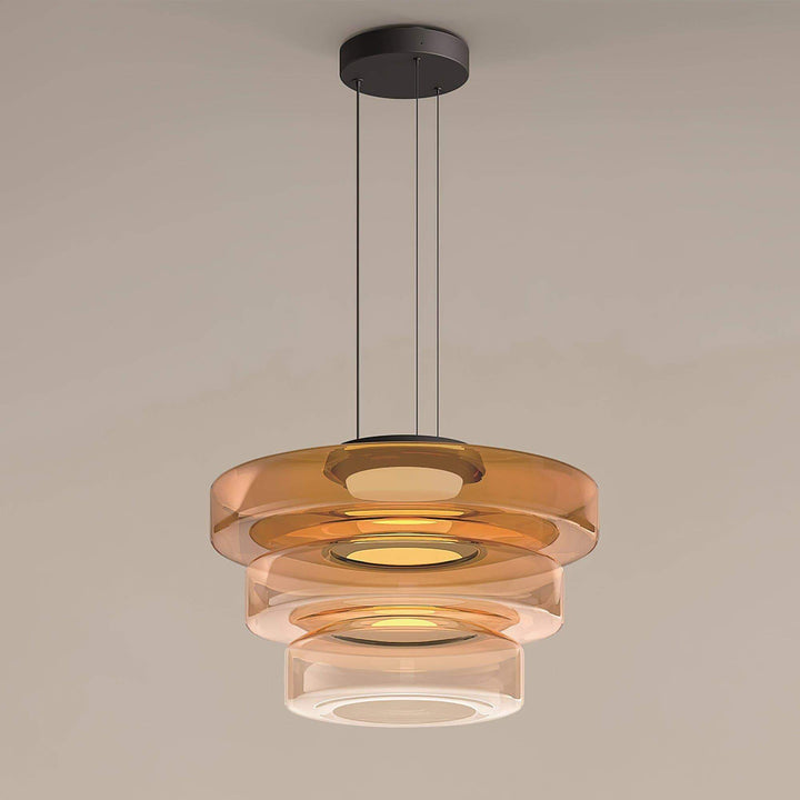 Full view of an orange three-layer glass pendant light with black canopy and adjustable suspension