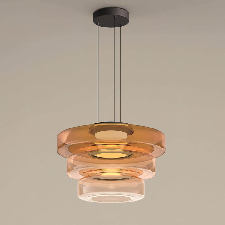 Orange three-layer glass pendant light with graduated circular shades and black ceiling canopy