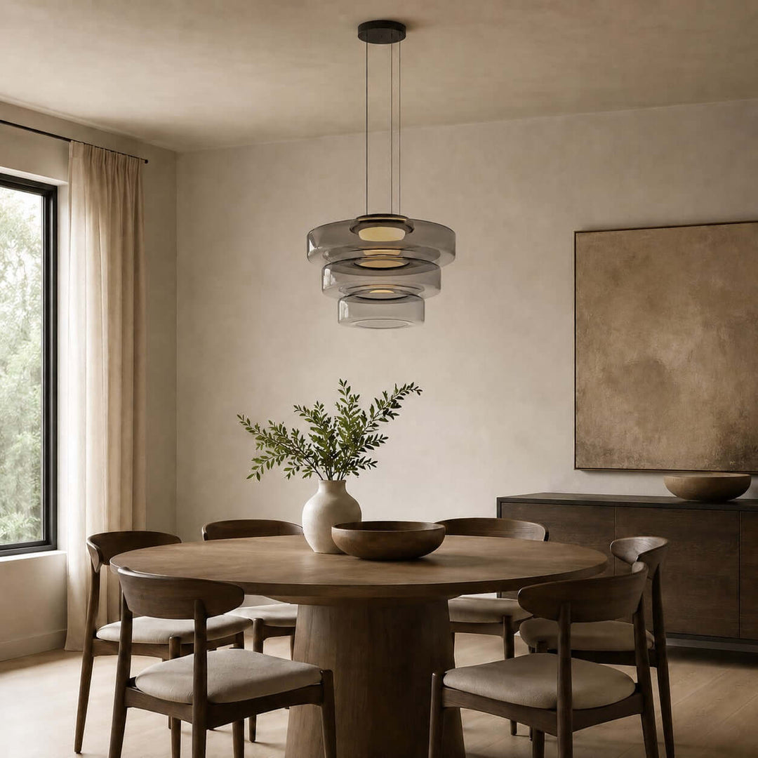Smoke Grey three-layer glass pendant light suspended above a large round wood dining table