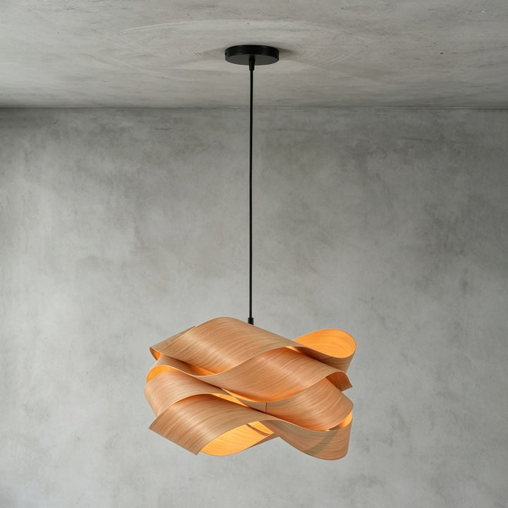 Link wood pendant light with a black canopy installed against a gray concrete wall