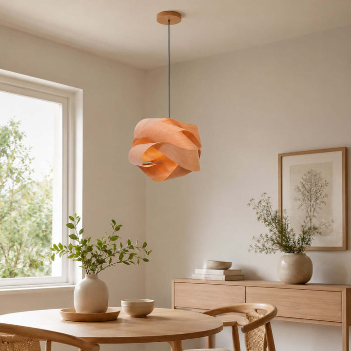 Link wood pendant light over a dining table beside a low wood sideboard