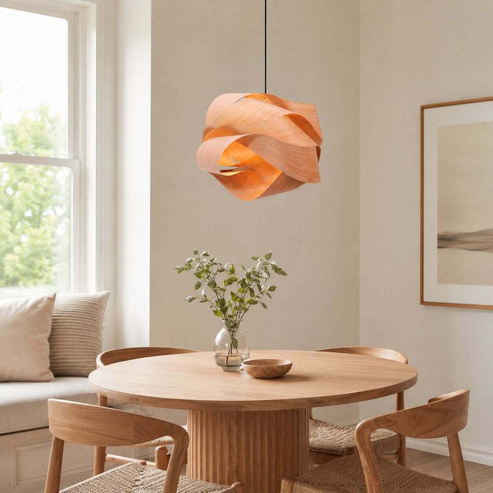 Link wood pendant light above a round dining table beside a bright window