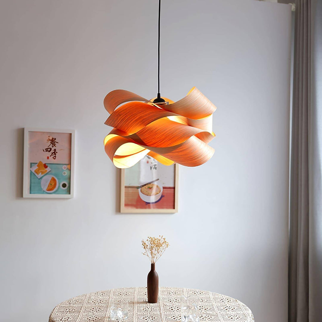 Glowing Link wood pendant light over a small round dining table with framed wall art