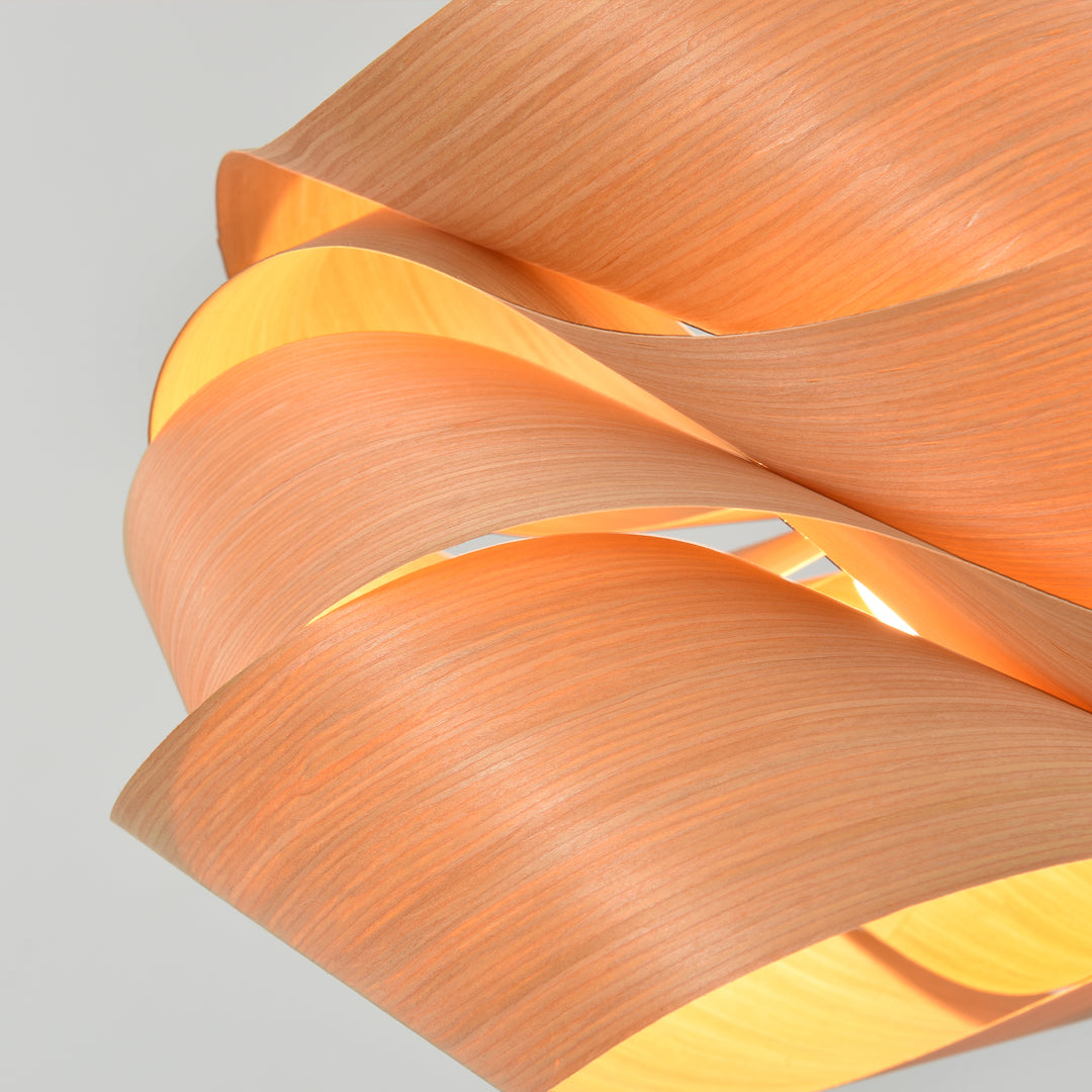 Macro detail of the Link pendant light showing wood veneer grain and warm inner light