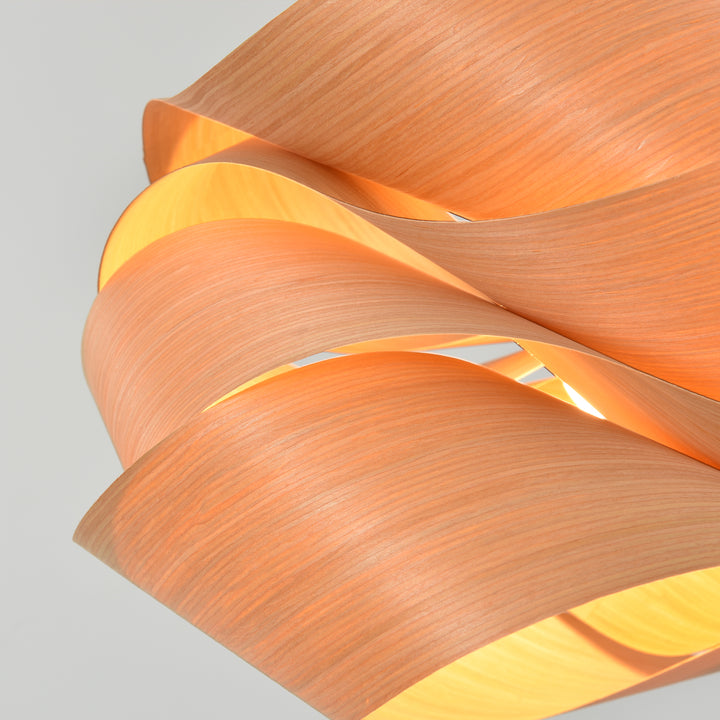 Macro detail of the Link pendant light showing wood veneer grain and warm inner light