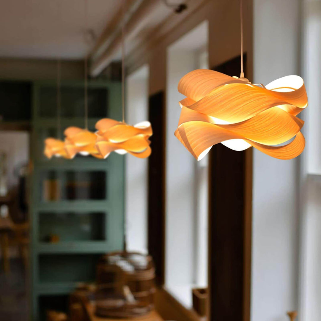 Row of glowing Link wood pendant lights beside tall windows in a restaurant interior