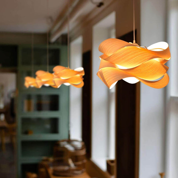 Row of glowing Link wood pendant lights beside tall windows in a restaurant interior