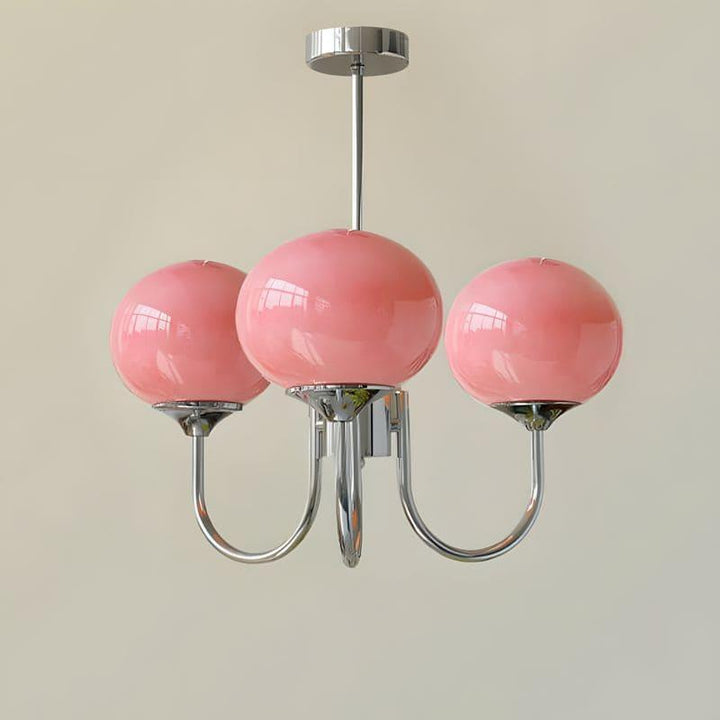 Three-light Marshmallow chandelier with a chrome frame and pink glass globes.
