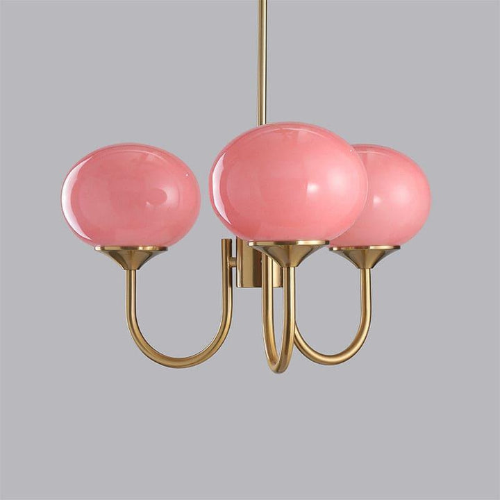 Three-light Marshmallow chandelier with a copper frame and pink glass globes.

