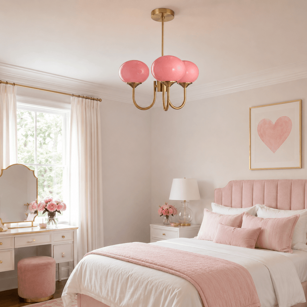Three-light pink glass chandelier in a bright bedroom with soft blush decor.

