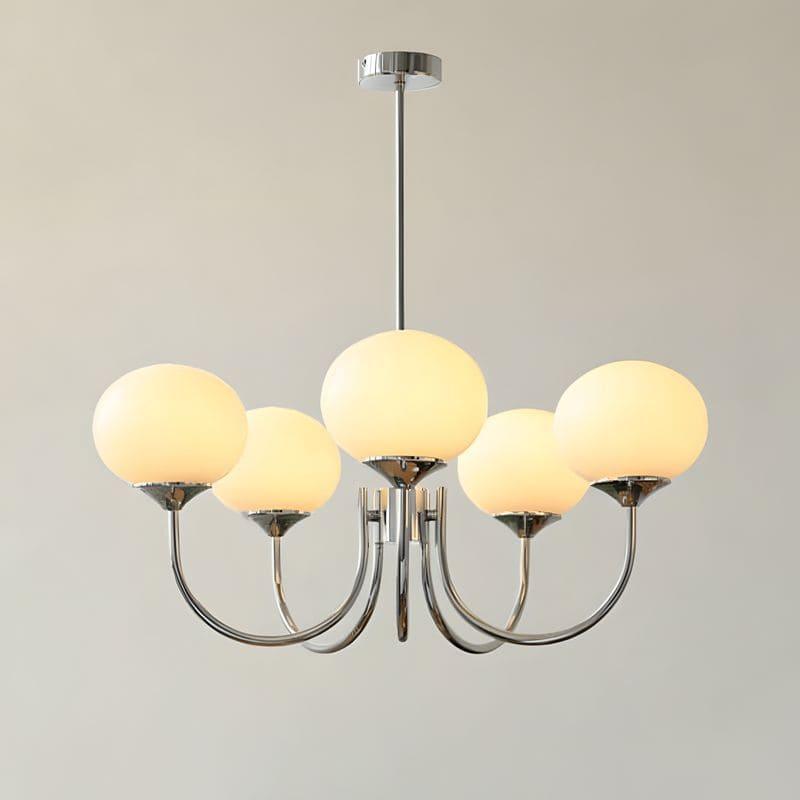Illuminated five-light chandelier with a chrome frame and warm cream glass globes.