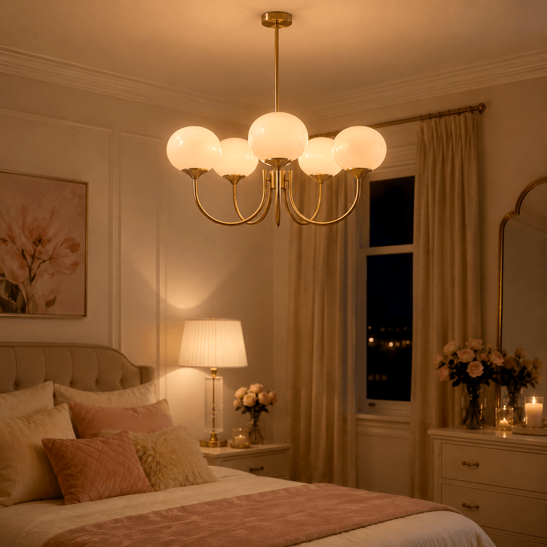 Illuminated five-light cream glass chandelier creating a warm glow in a bedroom at night.
