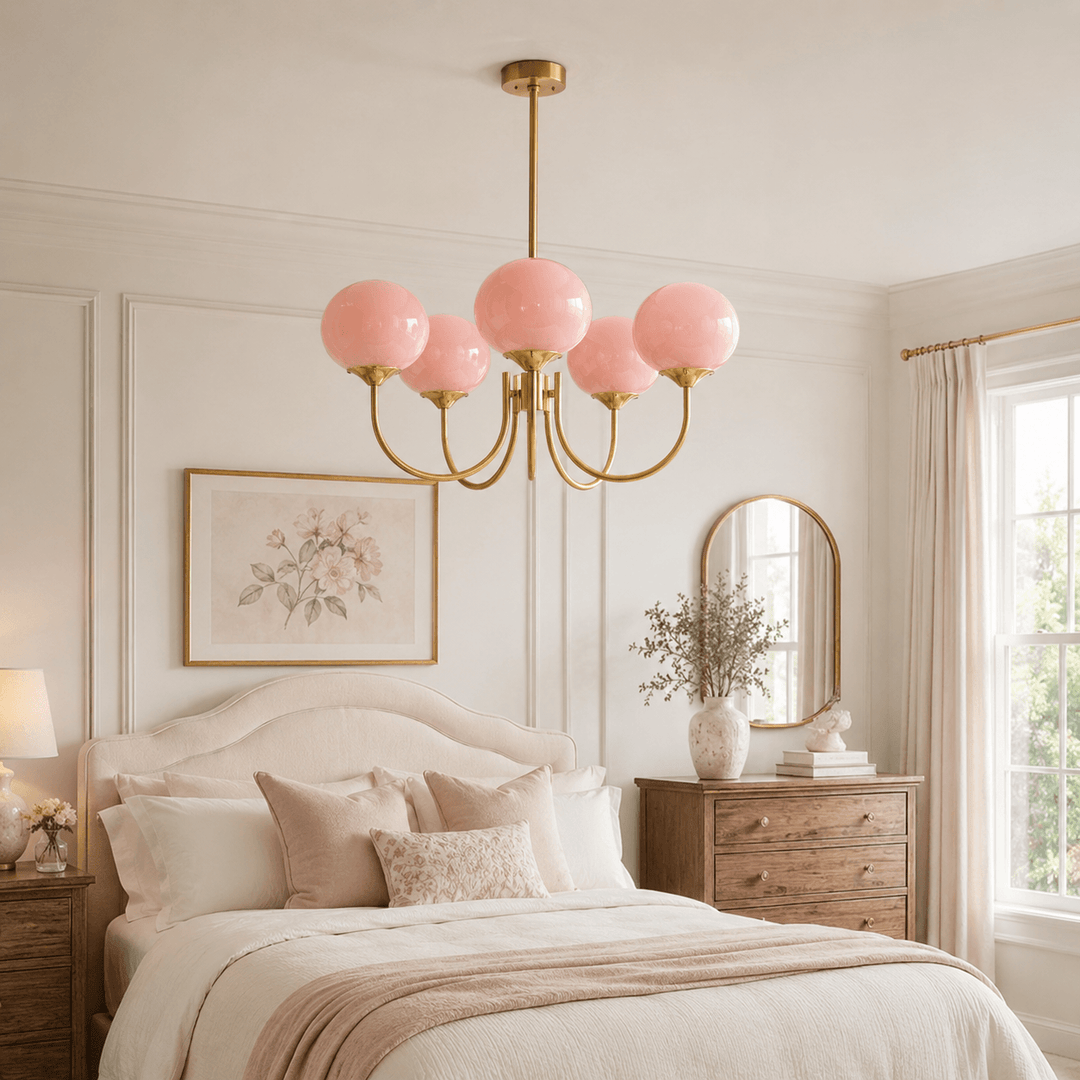 Five-light pink glass Marshmallow chandelier centered above a traditional upholstered bed.
