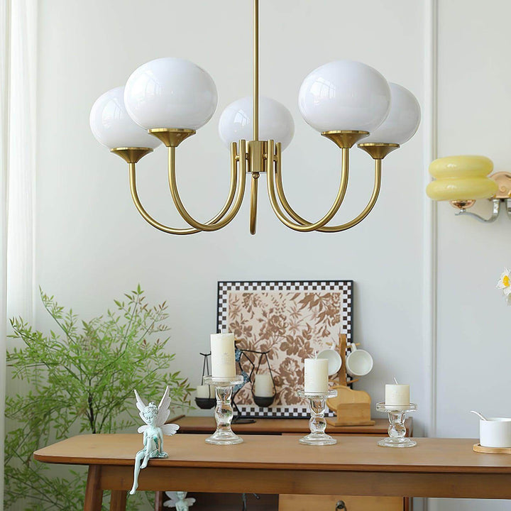 Five-light white glass chandelier with a copper frame shown in a bright interior.
