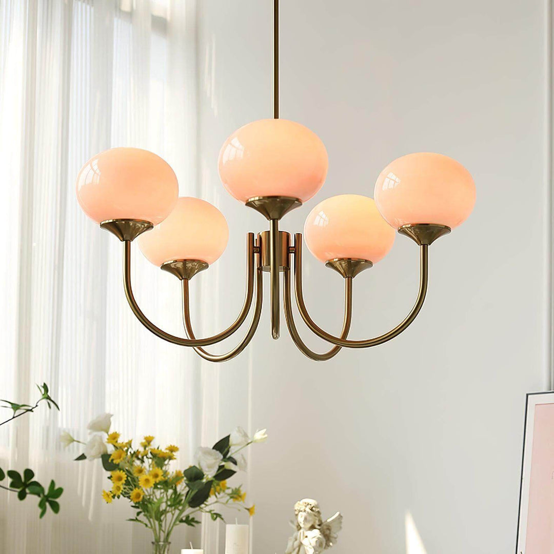 Illuminated front view of the five-light Marshmallow pink glass chandelier.
