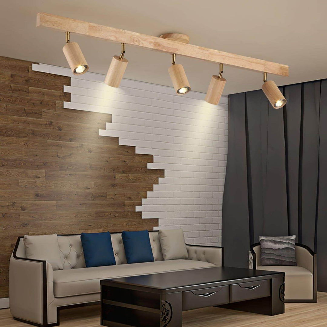 Five-head Merlo natural wood track lighting illuminating a living room with wood and white brick feature walls