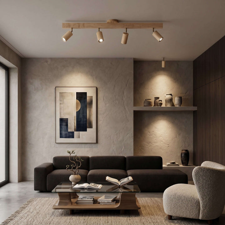 Four-head Merlo natural wood track lighting illuminating a contemporary living room with wall art
