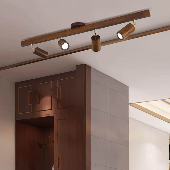 Four-head Merlo walnut wood track lighting mounted above dark wood cabinetry with adjustable spotlights
