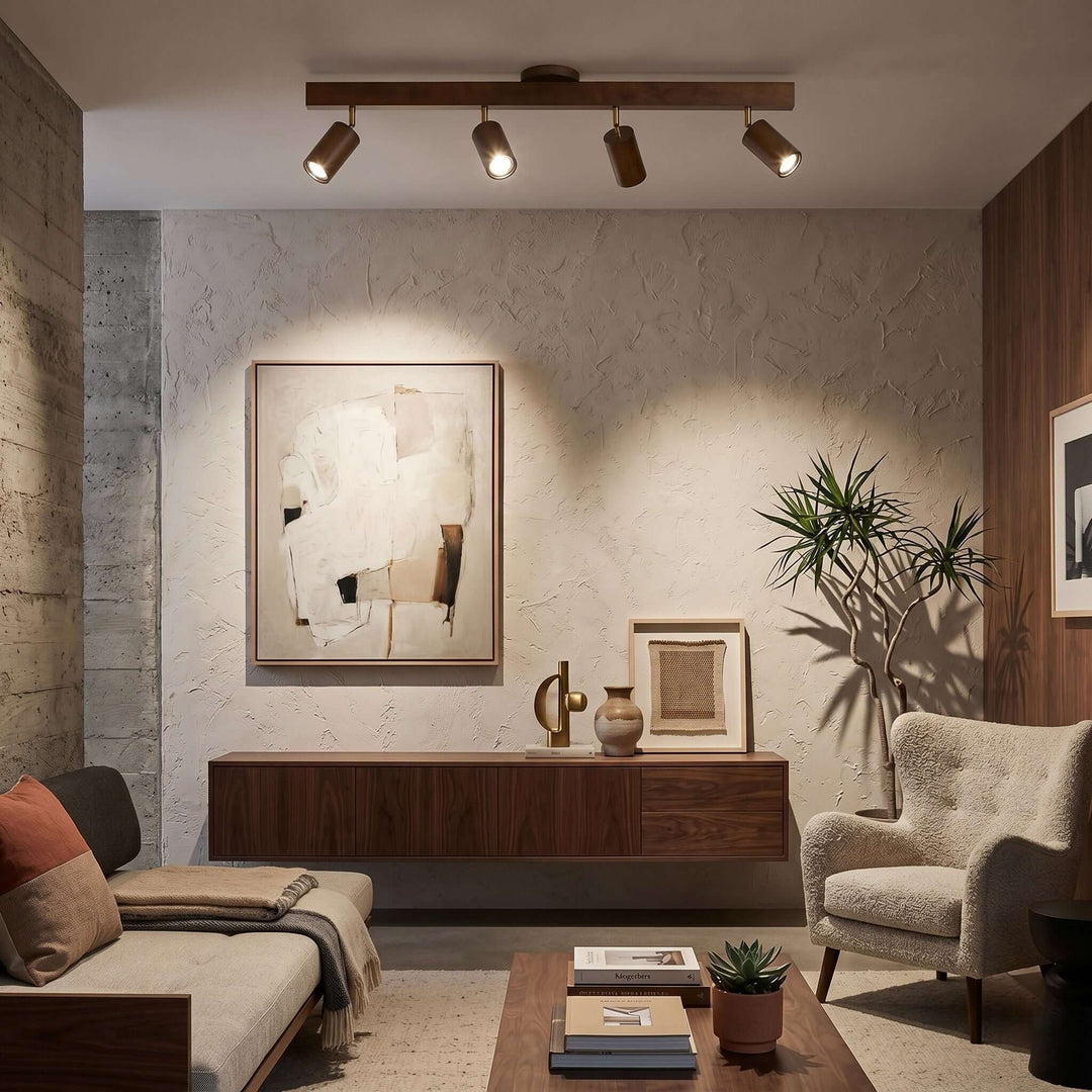 Four-head Merlo walnut track lighting directing warm light toward artwork in a modern living room