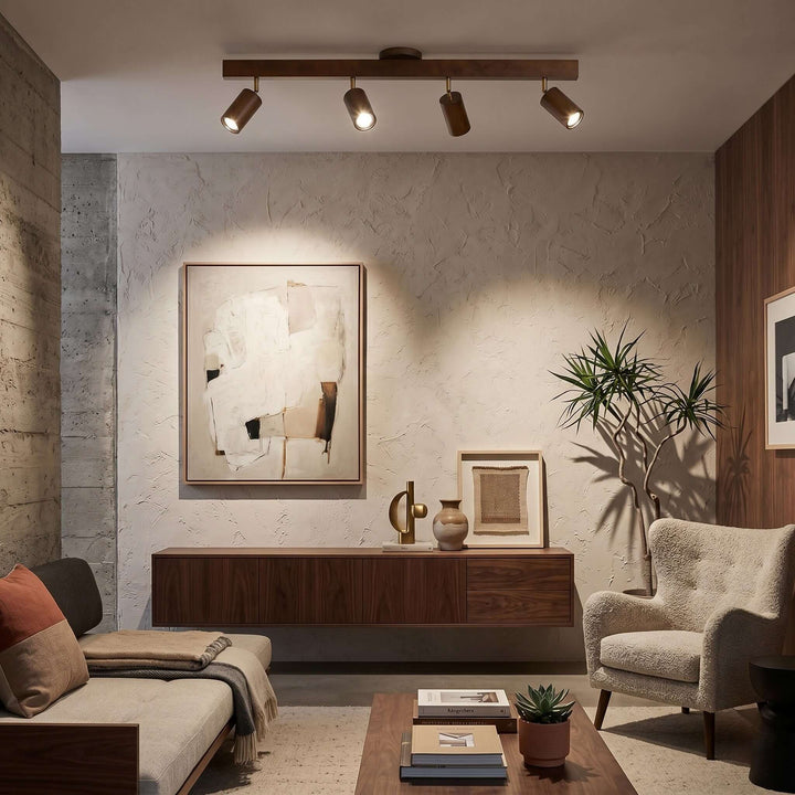 Four-head Merlo walnut track lighting directing warm light toward artwork in a modern living room