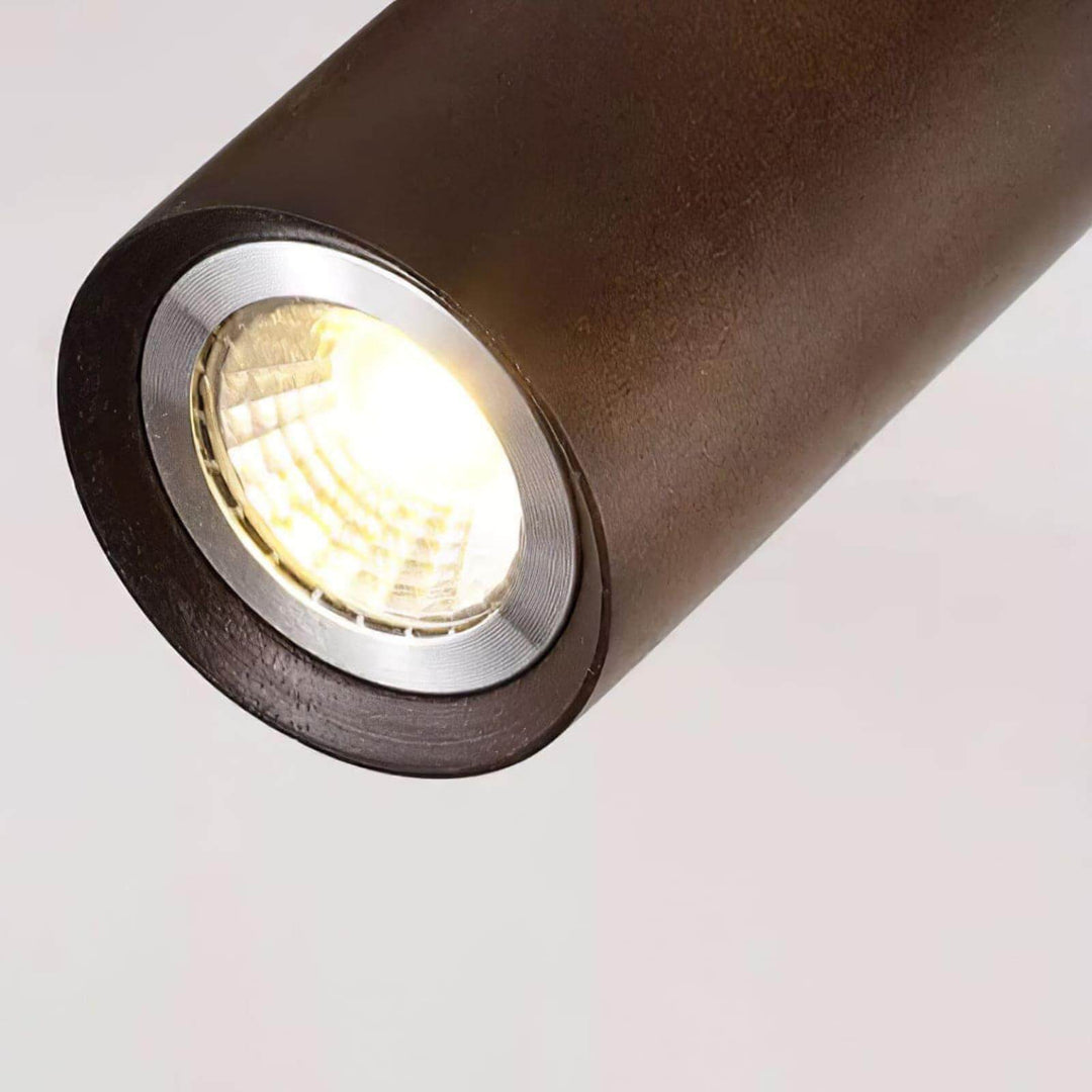 Close-up of a Merlo walnut spotlight head showing the cylindrical wood housing and reflective lens
