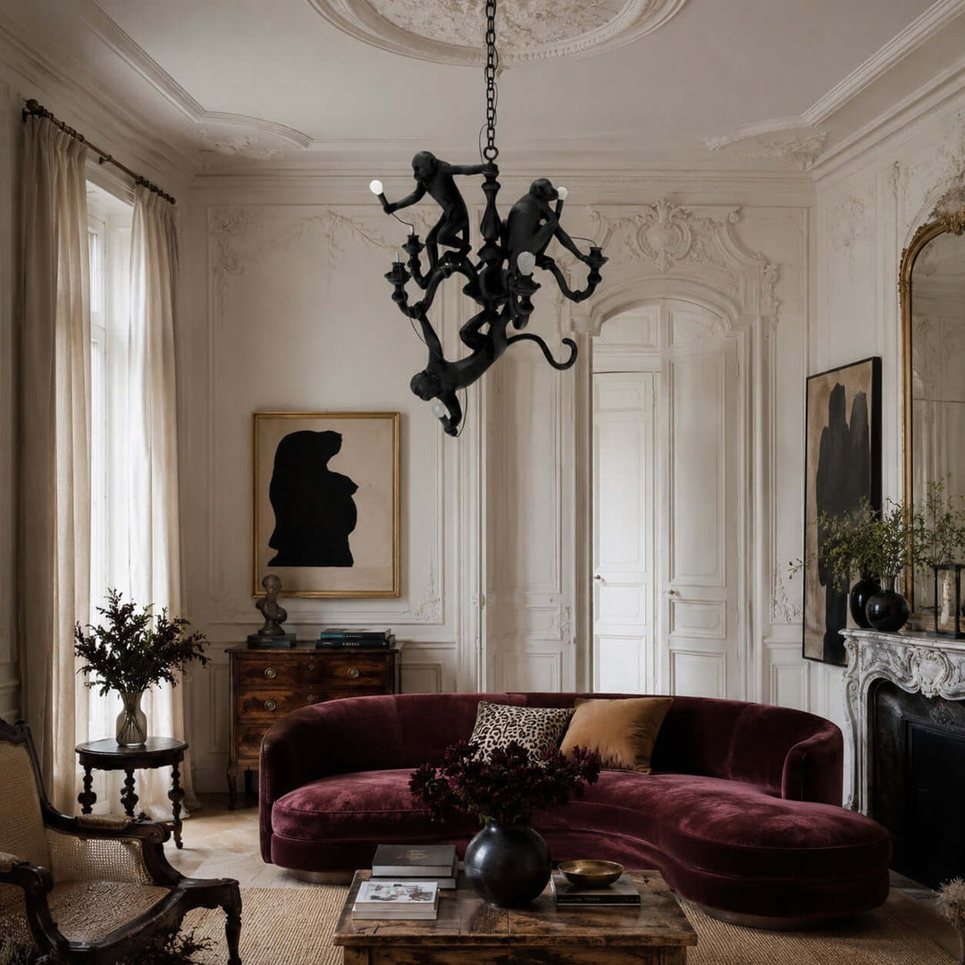 Black monkey chandelier above a classic living room with a burgundy velvet sofa