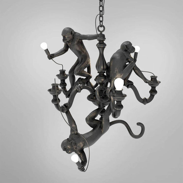 Black Monkey Chandelier with three resin monkey figures and exposed bulbs on a gray background