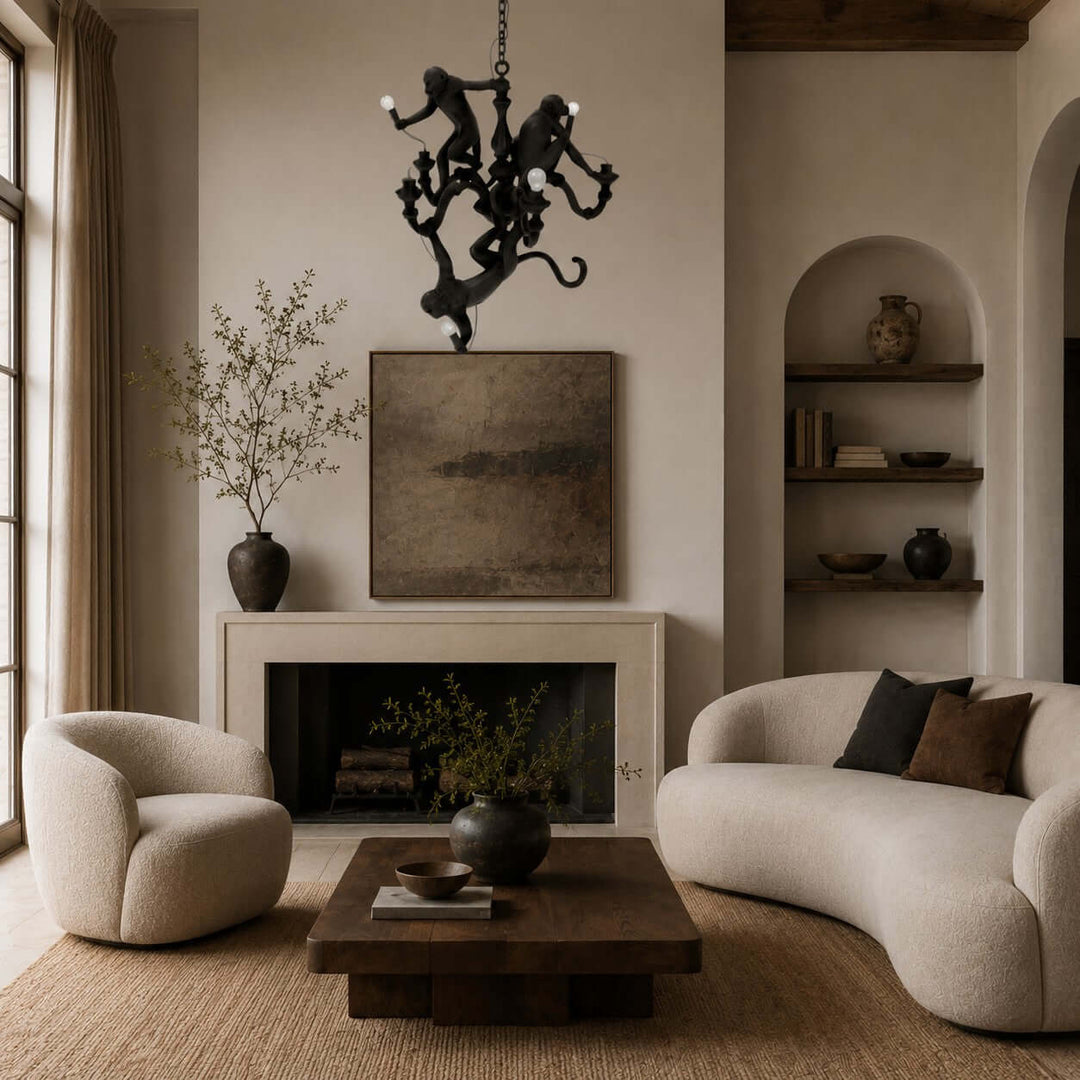 Black three-monkey chandelier in a warm organic modern living room with a stone fireplace