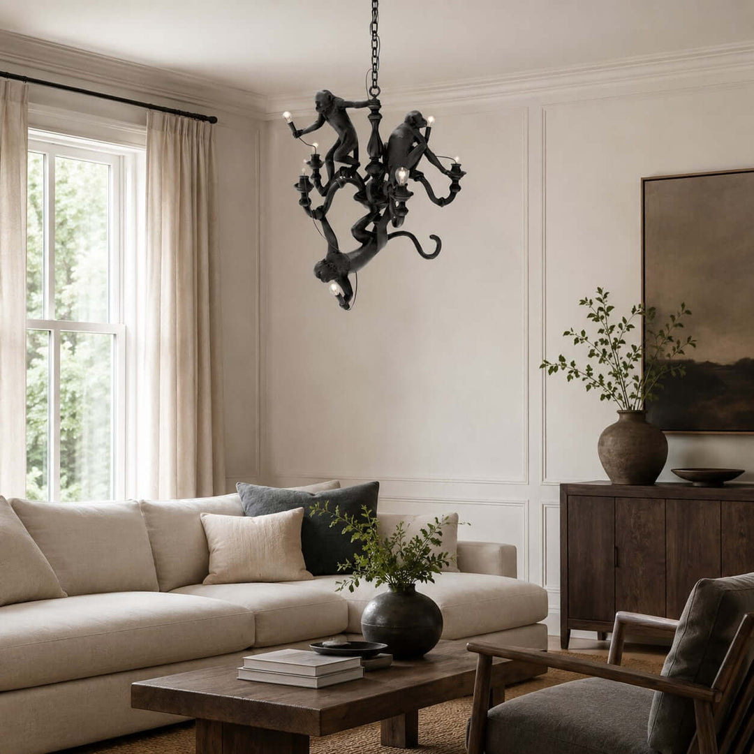 Black three-monkey chandelier in a bright contemporary living room with a cream sectional sofa