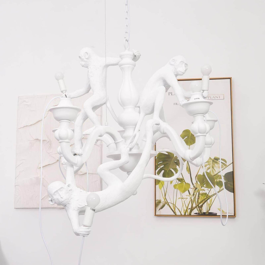 White Monkey Chandelier displayed in a bright interior with botanical wall art