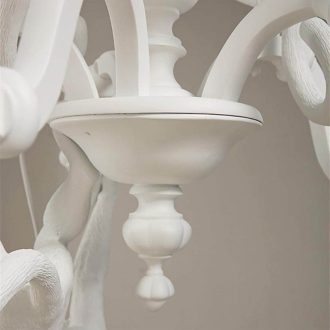 Close-up of the white Monkey Chandelier center bowl and curved candle-style arm