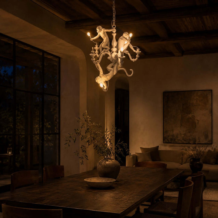 White Monkey dining room chandelier casting a warm glow above a long table at night