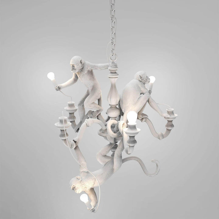 White Monkey Chandelier with three resin monkey figures and exposed bulbs on a gray background