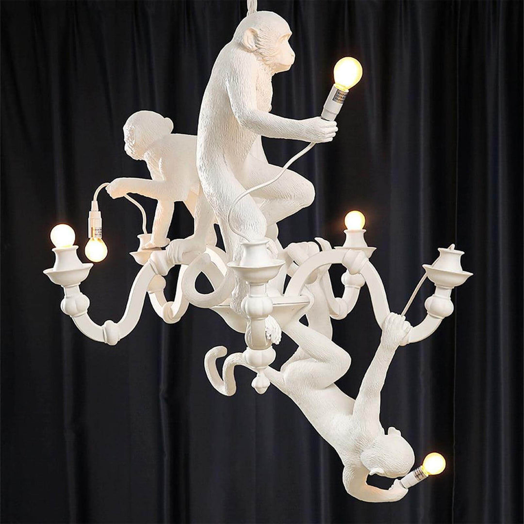 Alternate rear view of the illuminated white Monkey Chandelier against a black curtain