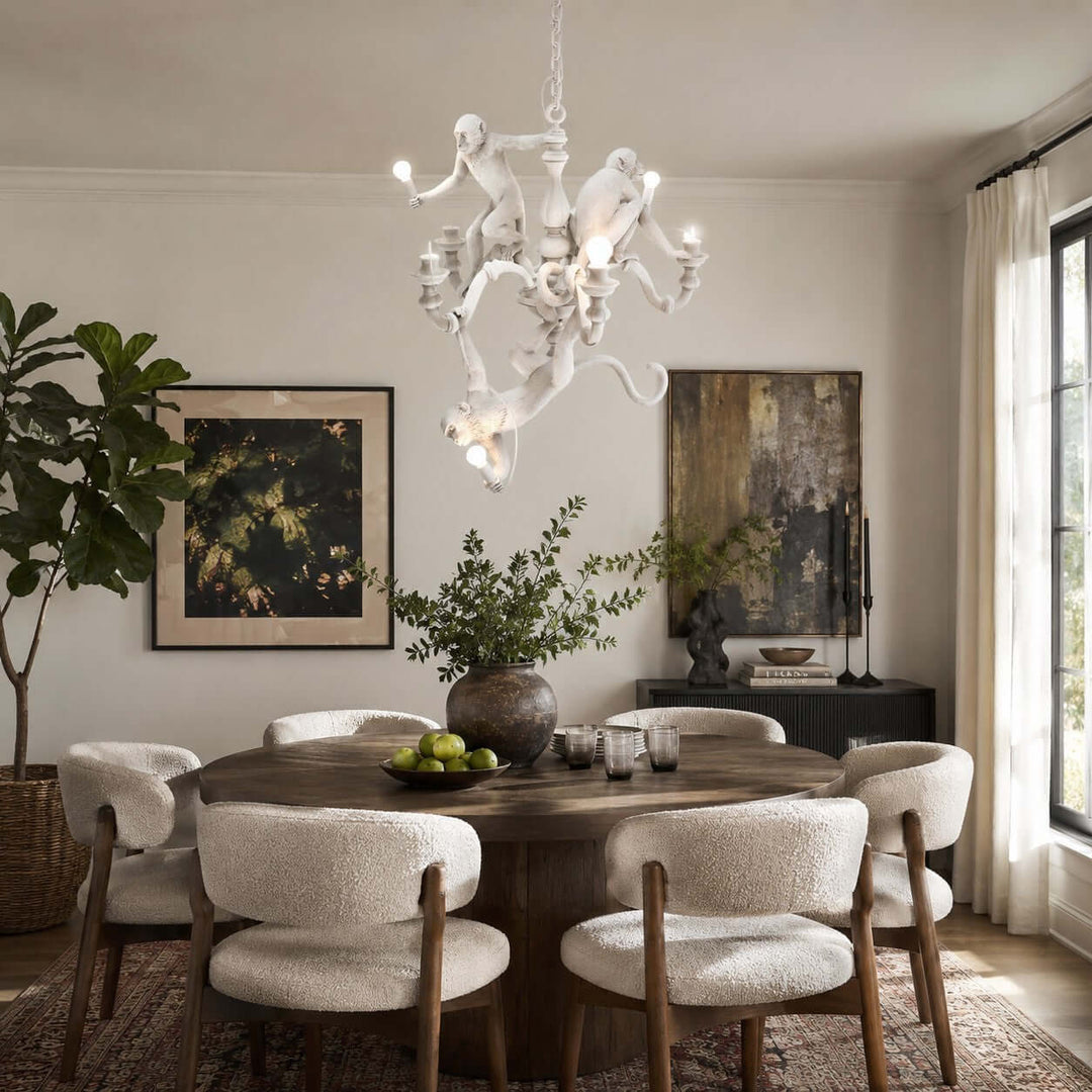 White Monkey Chandelier above a round dark wood dining table in a bright art-filled room