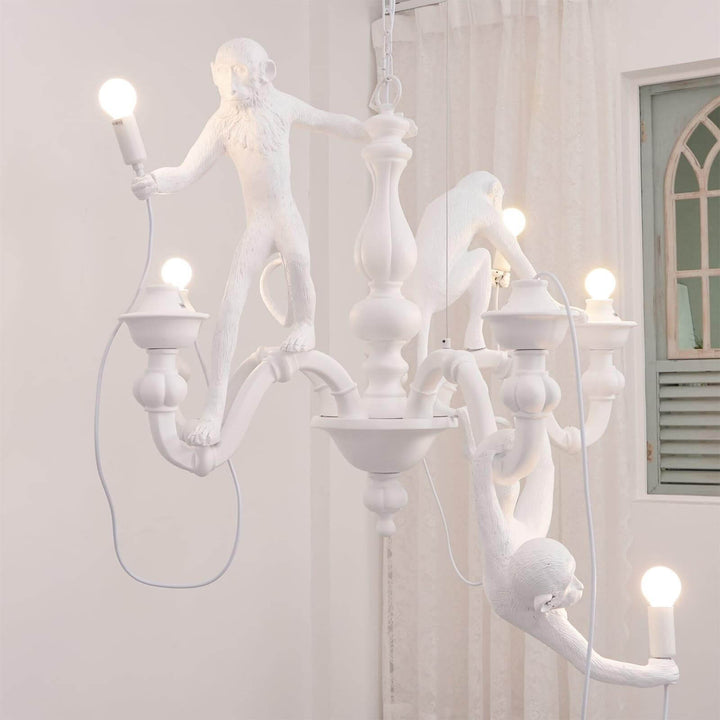 Side view of the white Monkey Chandelier installed near a window in a bright room