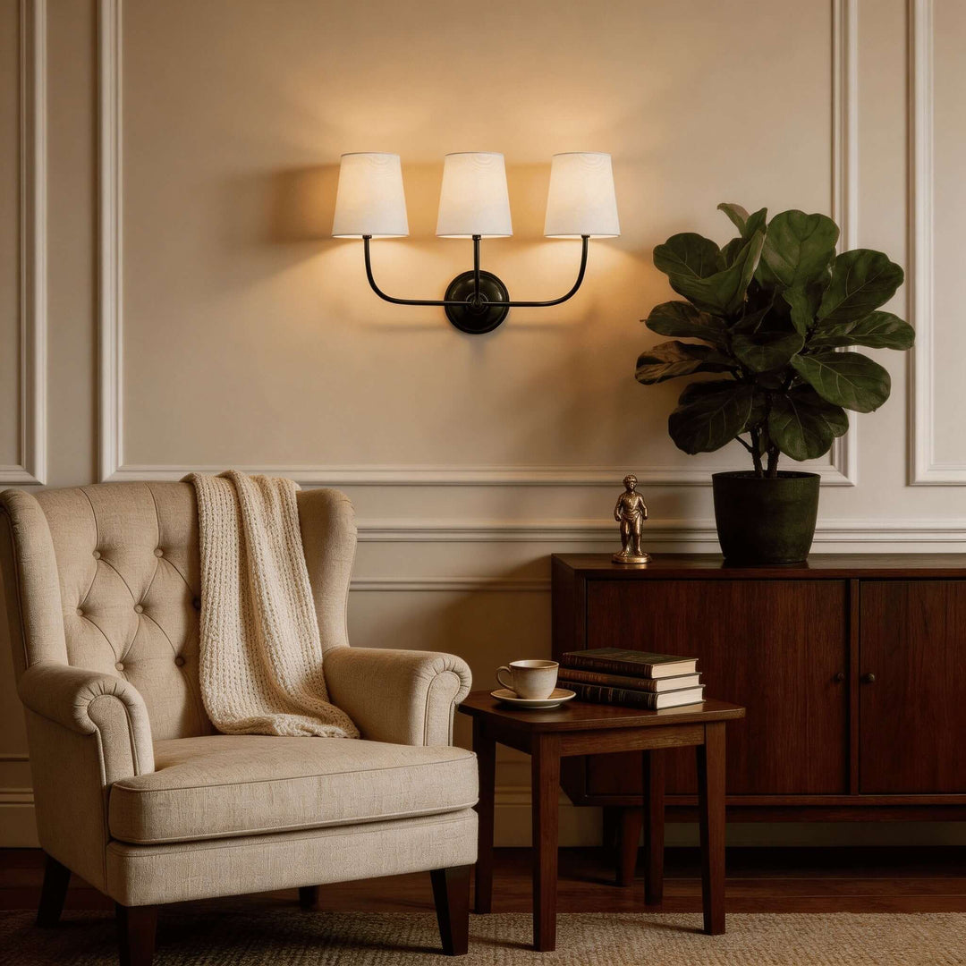 Black three-light Multi Wall Sconce above an armchair in a classic living room