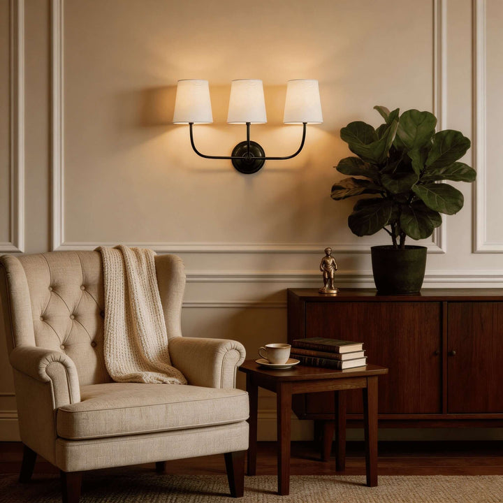 Black three-light Multi Wall Sconce above an armchair in a classic living room