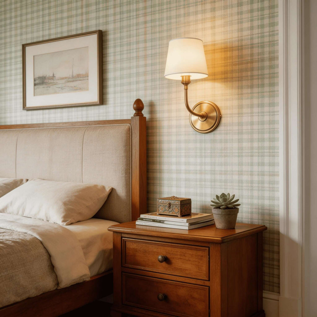 Brass single-light Multi Wall Sconce on plaid wallpaper beside a wood bed