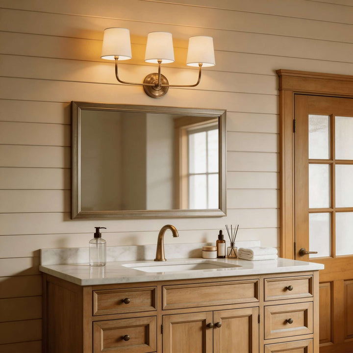 Brass three-light Multi Wall Sconce above a bathroom vanity mirror