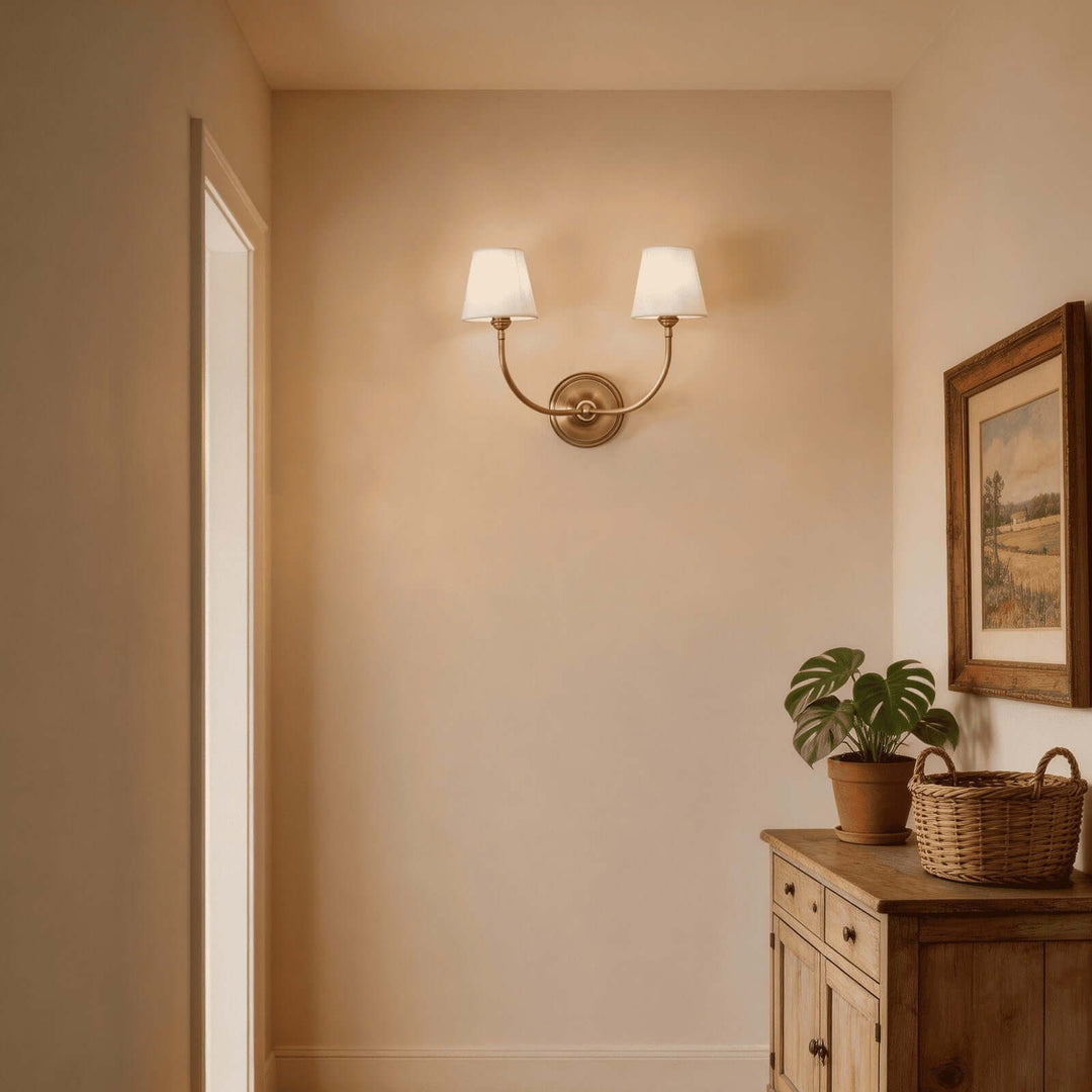 Brass two-light Multi Wall Sconce casting warm light in a traditional hallway