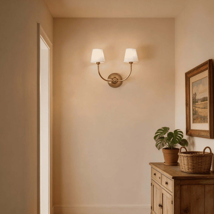 Brass two-light Multi Wall Sconce casting warm light in a traditional hallway