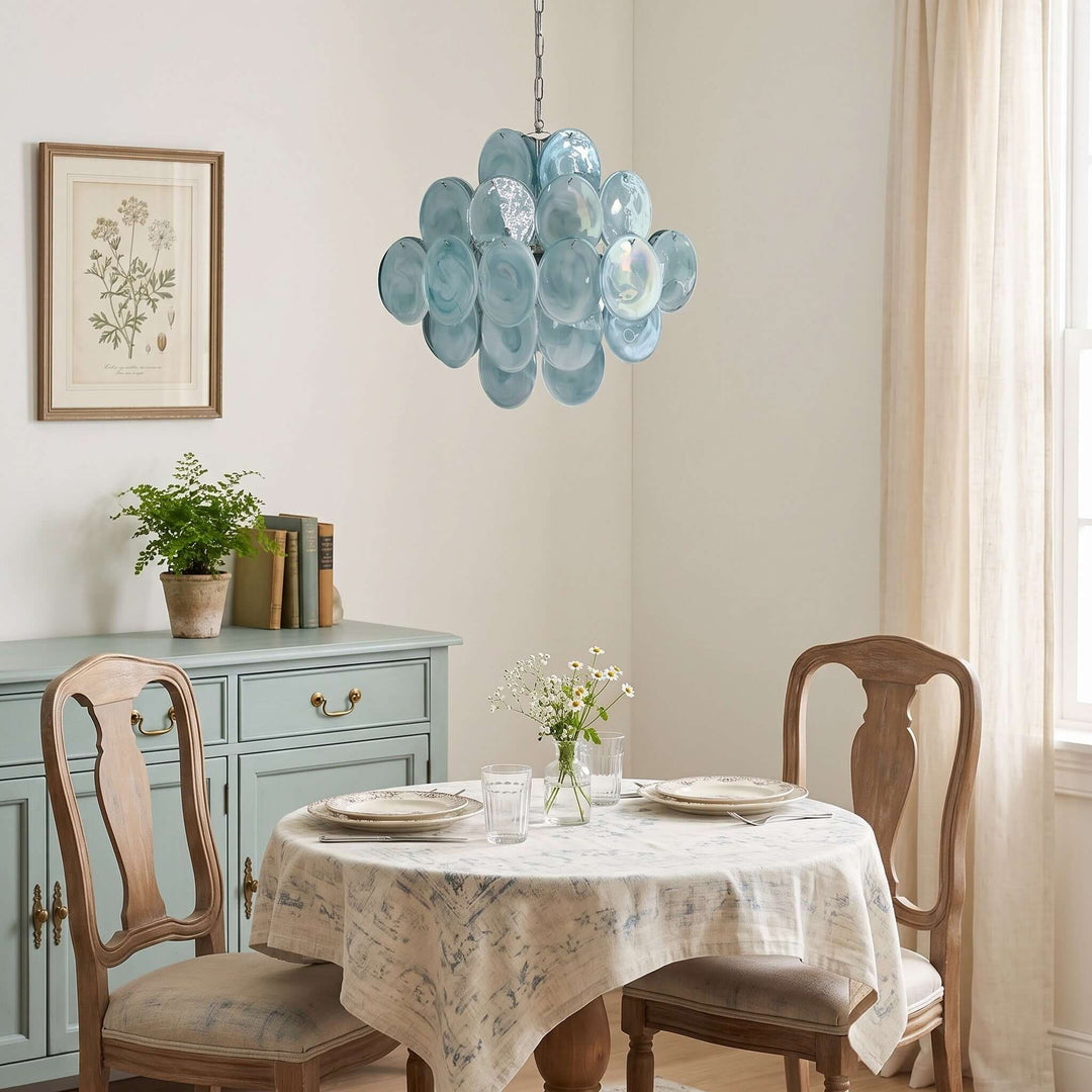 Blue Murano glass dining room chandelier above a round table in a softly styled classic interior