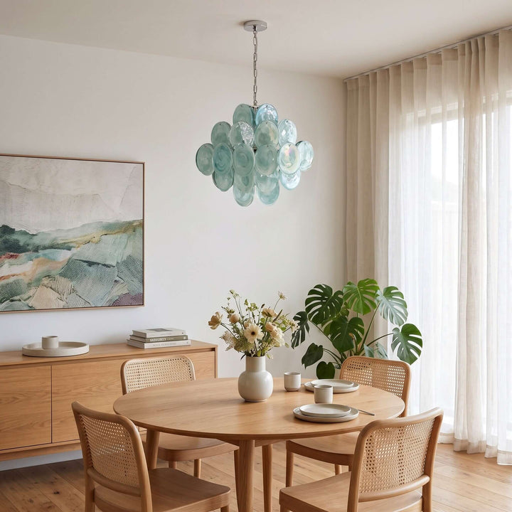 Green Murano Disk dining room chandelier above a round wood table in a bright modern interior