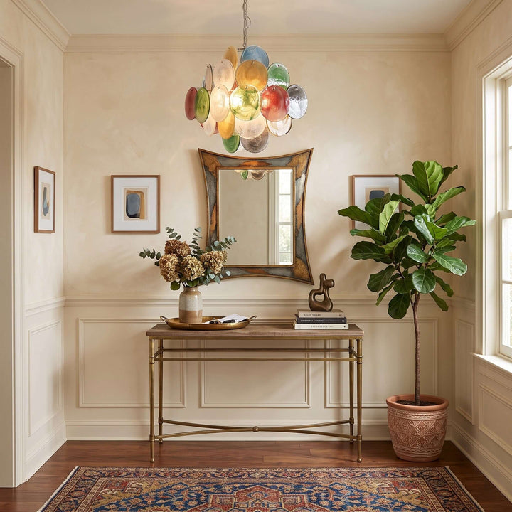 Multicolor Murano Disk Chandelier above a brass console and sculptural mirror in a traditional entryway